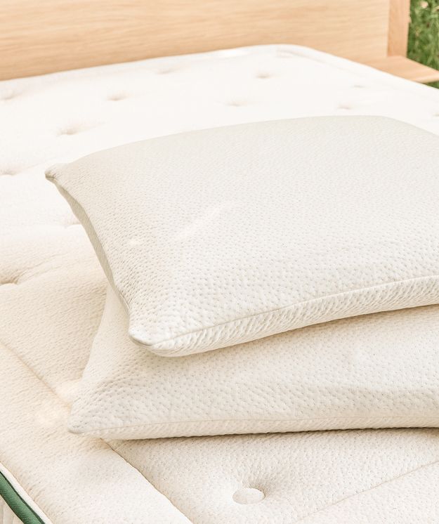 Cuscini in lattice naturale Kipli appoggiati su un materasso ecologico in lattice, a testimonianza di una biancheria da letto sana e sostenibile.