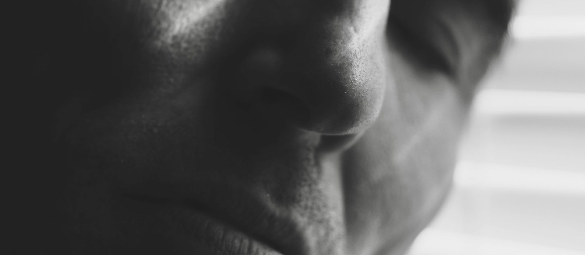 Primo piano del volto di una persona addormentata, fotografato in bianco e nero.